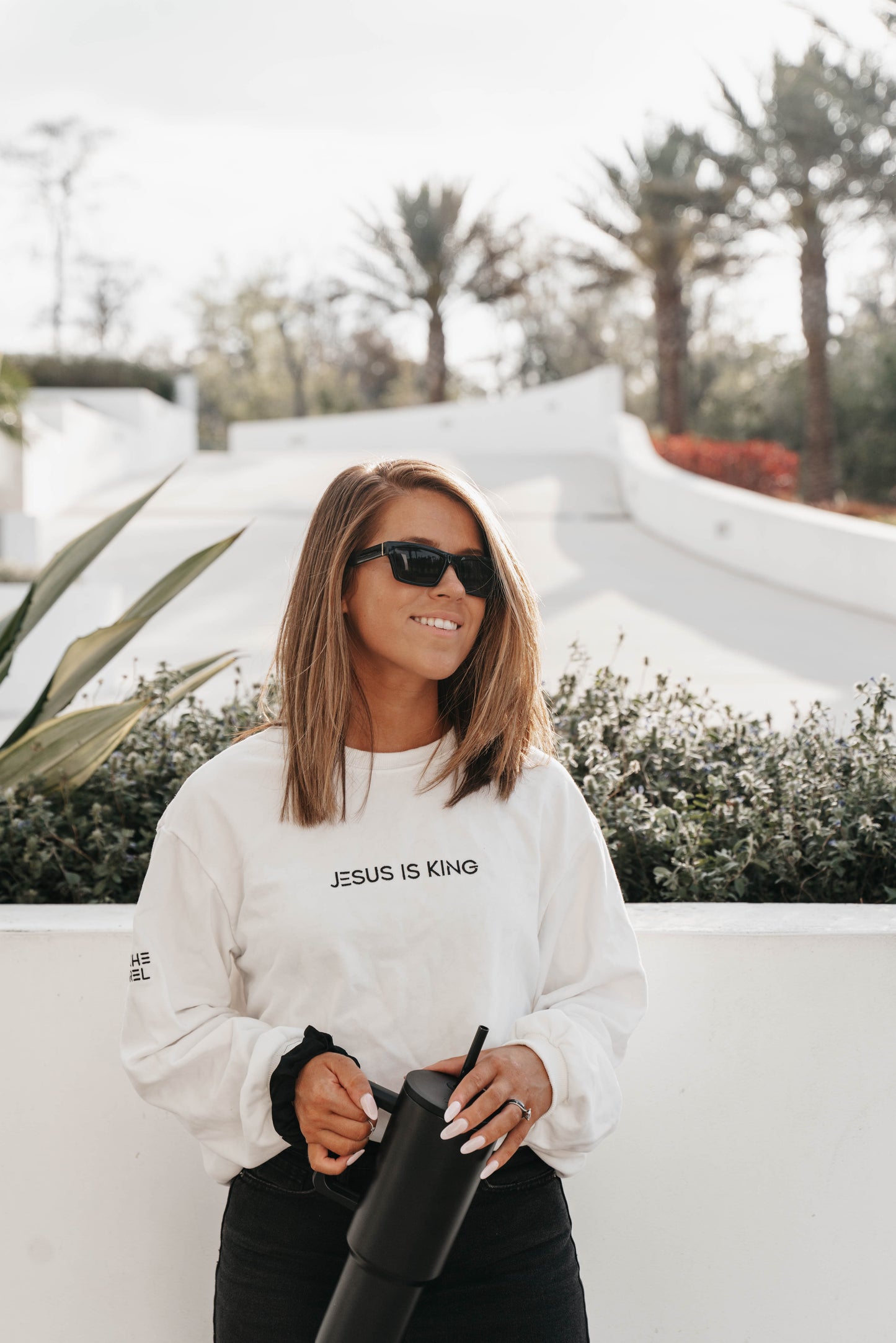 Woman in “Jesus Is King” long sleeve shirt – clean faith-based fashion