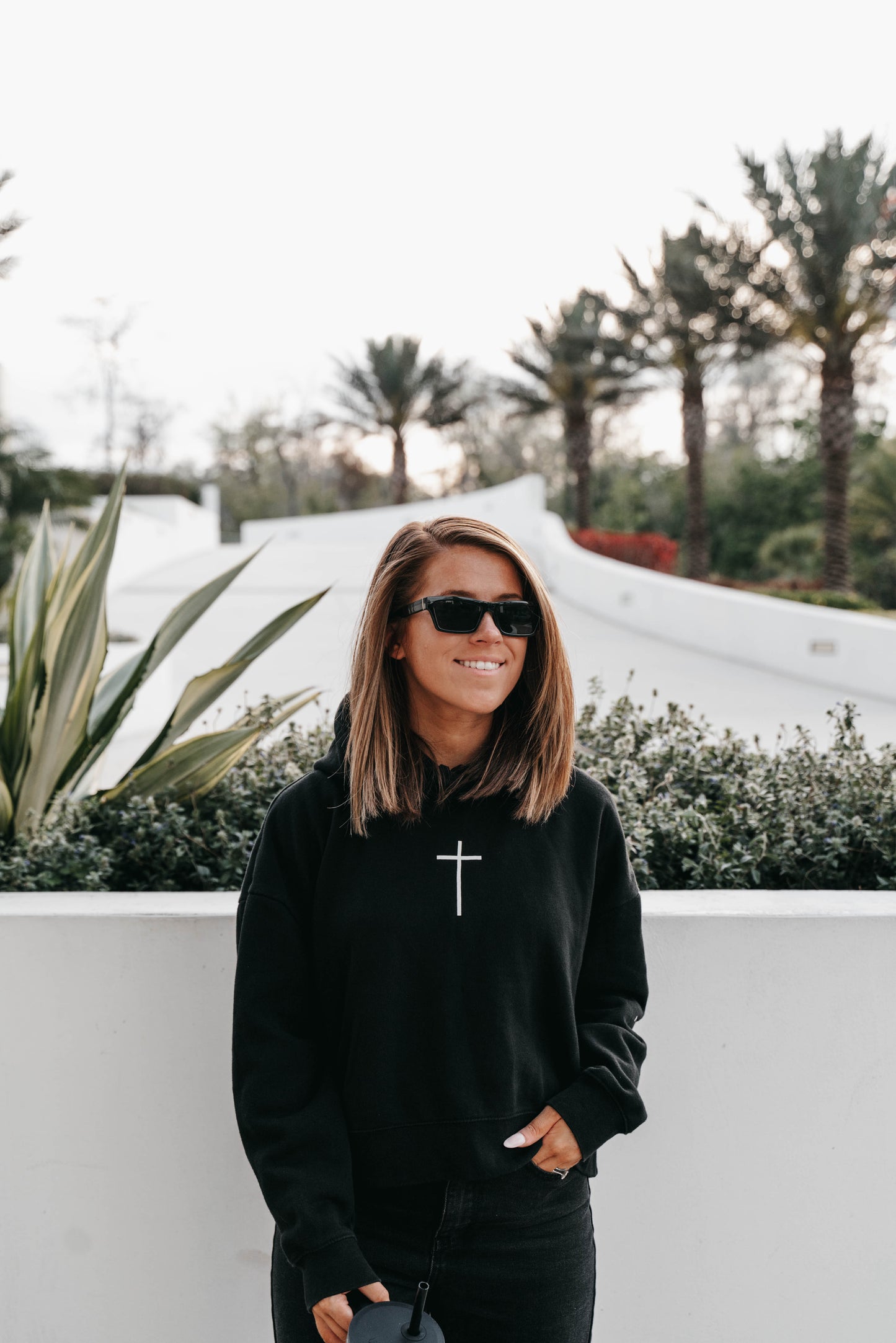 Cropped black hoodie with “We Owe A Debt” – women’s Christian fashion